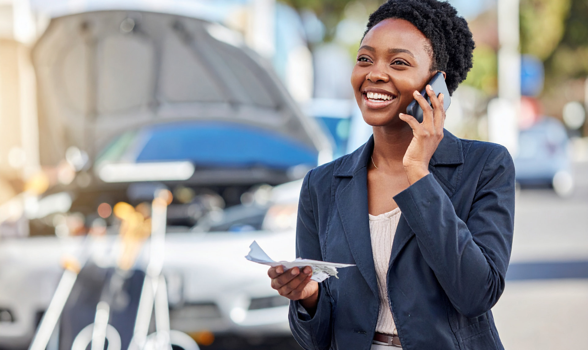 Smiling McKenzie & Snyder client holding her settlement check on the phone after an Ohio car accident